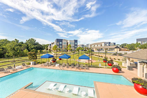 A pool with a slide and a building in the background.