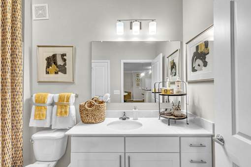 A bathroom with a white toilet, sink, and a mirror.