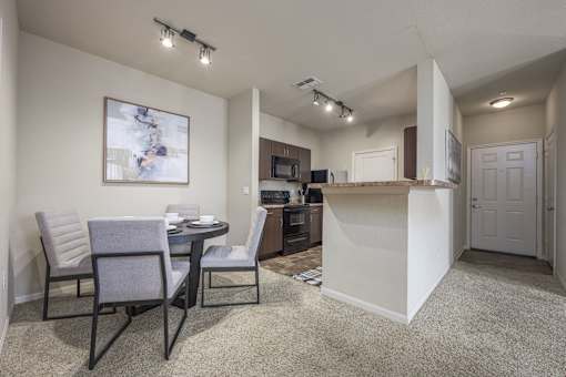 A kitchen area with a dining table and chairs.