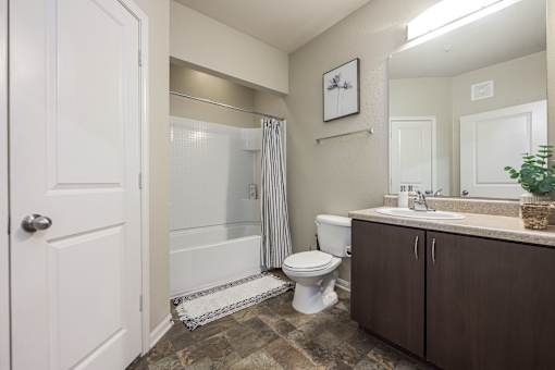 A bathroom with a toilet, sink, and shower.