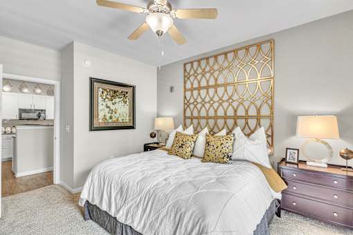 A bedroom with a large bed and a ceiling fan.