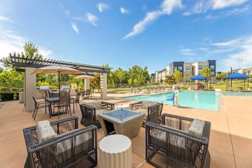 A poolside area with chairs and a table.