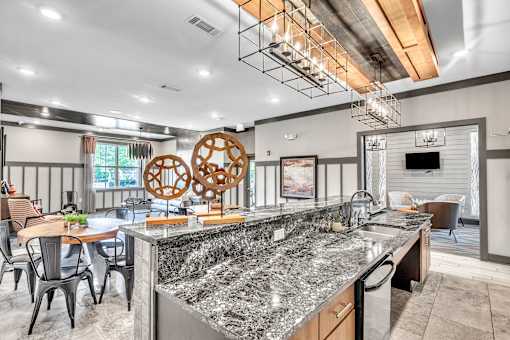 A modern kitchen with a granite countertop and a dining table with chairs.