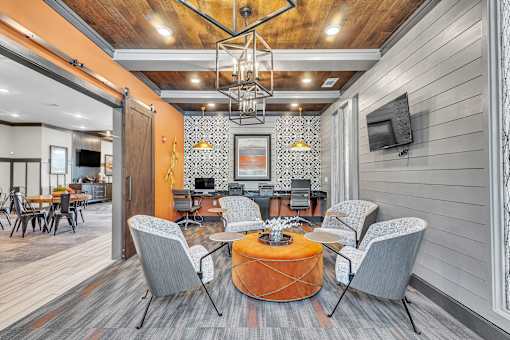 A modern living room with a wooden ceiling and grey chairs.