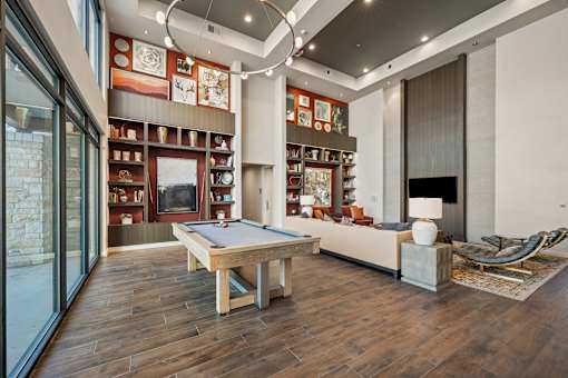 Billiard table is in the middle of a room with a couch and a chair at Edge and Stone, San Antonio, Texas