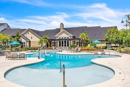 A large swimming pool in front of a house.