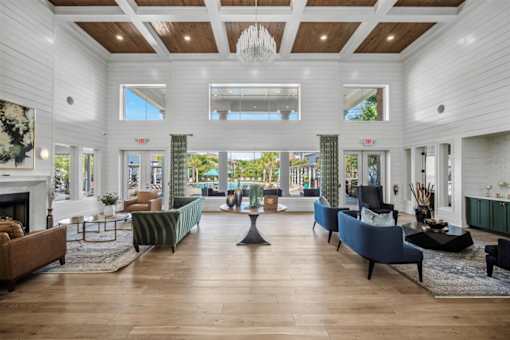 A large, well-lit living room with a fireplace and a variety of seating options.