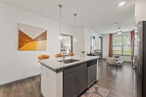 A modern kitchen with a large island and a painting on the wall.