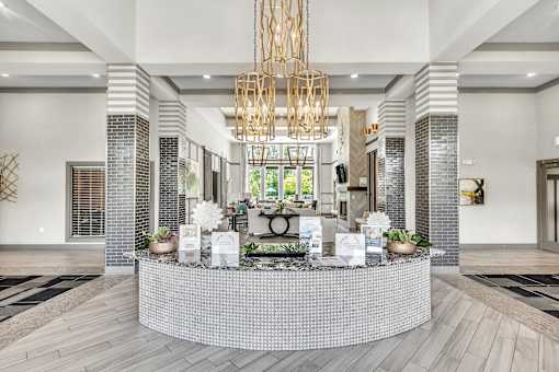 A reception area with a white reception desk and a large chandelier.
