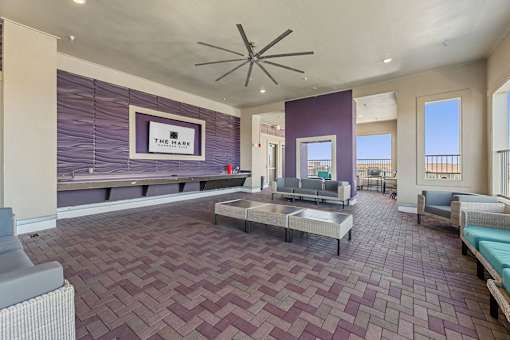 A spacious room with a purple tiled floor and a ceiling fan.