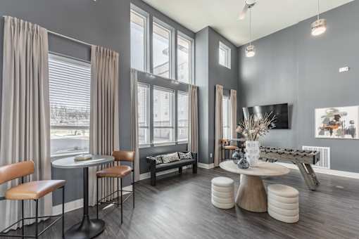 A modern living room with a grey theme and a large window at Prosper Madison Oaks, Madison, AL