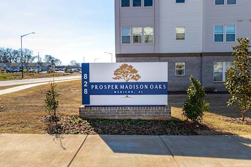 A sign for Prosper Madison Oaks is in front of a building.