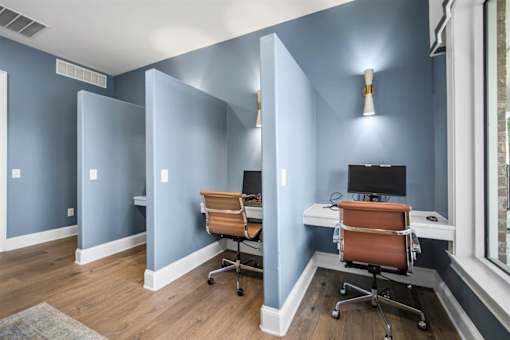 A room with two chairs and two desks.
