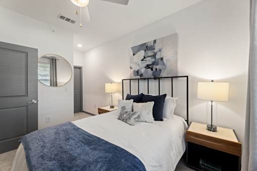 A bedroom with a large bed and a painting on the wall.