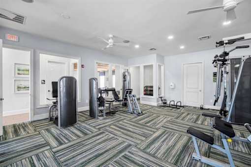 A gym with a variety of equipment including a treadmill, weights, and a stationary bike.