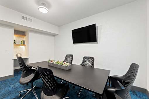 A conference room with a long table and chairs.