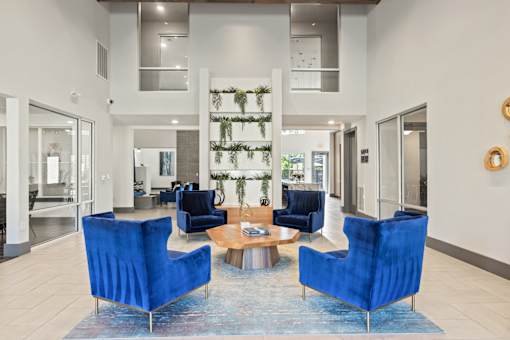 A living room with blue chairs and a rug.