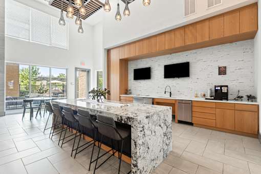 A kitchen with a marble island and wooden cabinets.