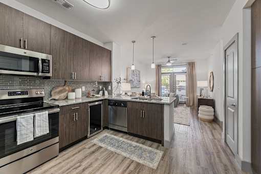 A modern kitchen with dark wood cabinets and stainless steel appliances.