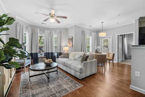 A living room with a couch, coffee table, and a ceiling fan.