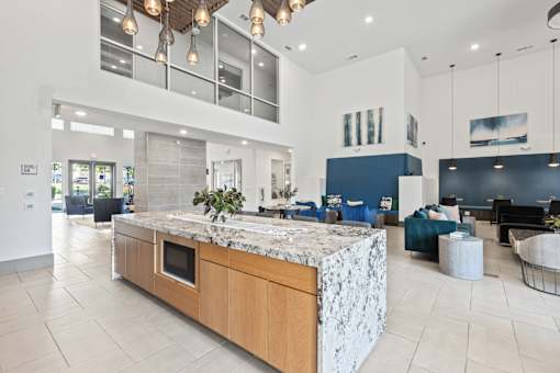 A modern kitchen with a marble island and wooden cabinets.