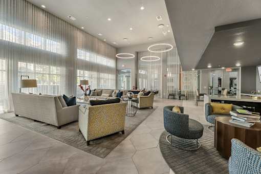 A modern living room with a large sofa, armchairs, and a coffee table.