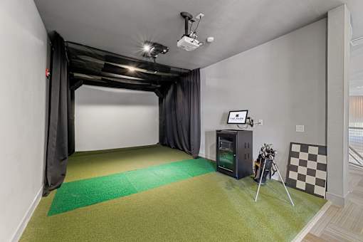 A room with a green carpet and a black and white checkered picture on the wall.