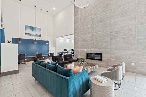 A living room with a blue couch and a fireplace.