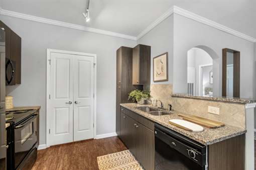 A kitchen with a black oven and a white door.