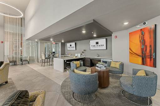 A modern lounge area with a variety of seating options and a large painting on the wall.