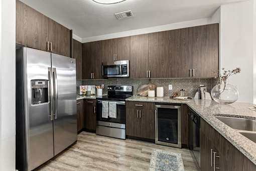 A modern kitchen with stainless steel appliances and wooden cabinets.