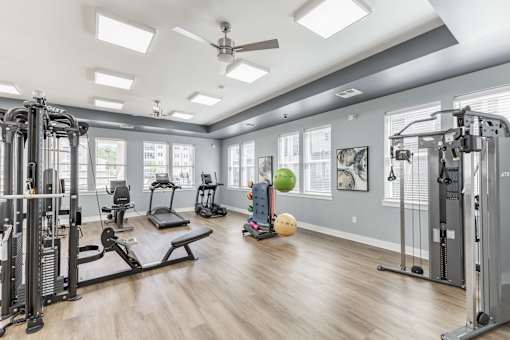 A spacious home gym with a variety of exercise equipment at Prosper Madison Oaks, Madison, AL