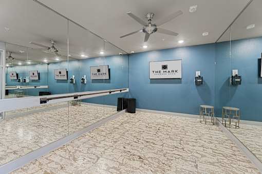 A spacious room with a marble floor and a mirrored wall.