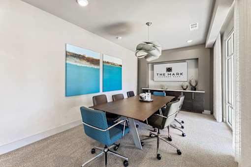 A conference room with a long table and chairs.