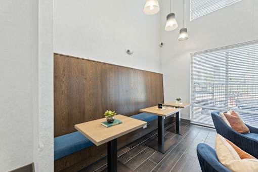 A modern dining area with a wooden bench and a table with a vase of flowers on it.