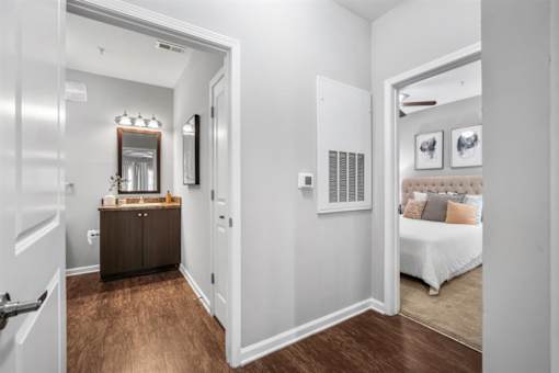 A bedroom with a white bed and a brown dresser.