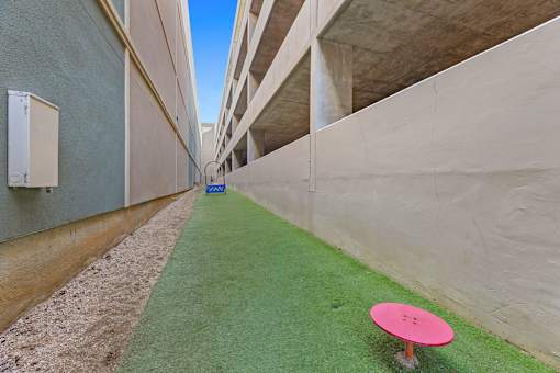 A pink frisbee golf hole is in the middle of a concrete courtyard.