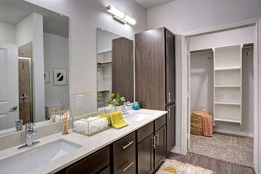 A bathroom with a sink, mirror, and wooden cabinets.