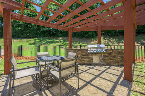 A patio with a table and chairs under a pergola.