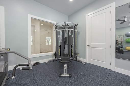 A home gym with a squat rack, a mirror, and a treadmill.