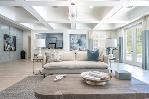 A modern living room with a large grey sofa and a wooden coffee table.