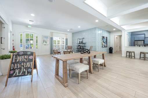 A room with a wooden table and chairs and a sign that says Happy New Year 2024.