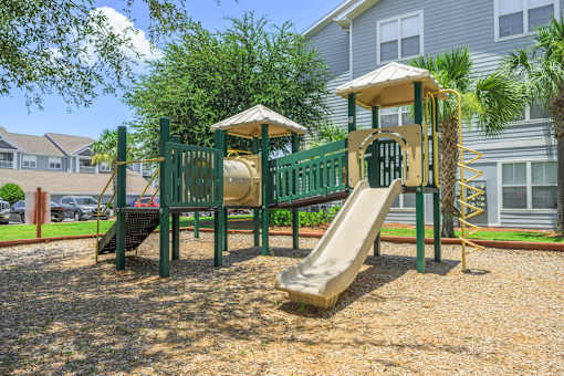 A playground with a green slide and a yellow slide.