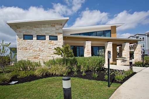 A modern house with a stone facade and a large glass window.