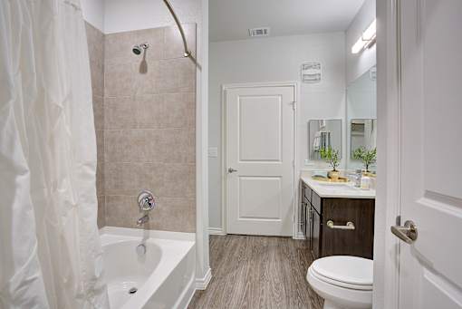 A bathroom with a toilet, sink, and shower.