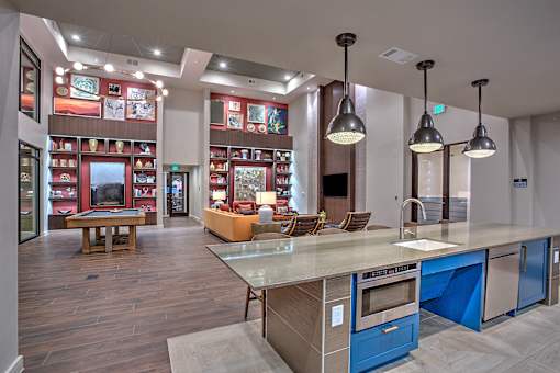 A modern kitchen with a large island and pendant lights.