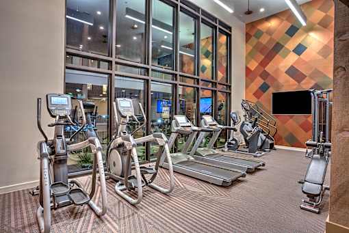 A gym with treadmills, exercise bikes, and elliptical machines.