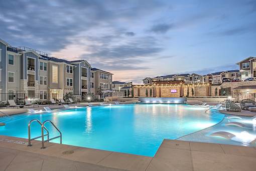 A large swimming pool in front of apartment buildings.