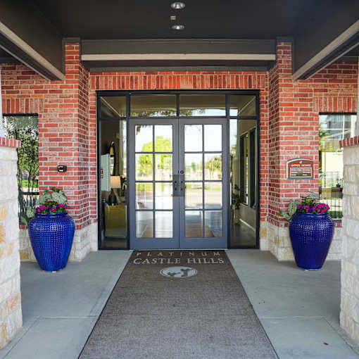 the front doors of the castle hills apartments are open