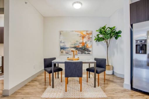 a dining room with a table and chairs and a painting on the wall at The Mark, San Antonio, TX